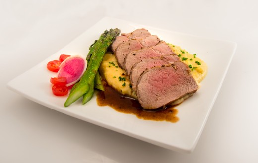 Herb-Crusted Pork Tenderloin Served Over Polenta